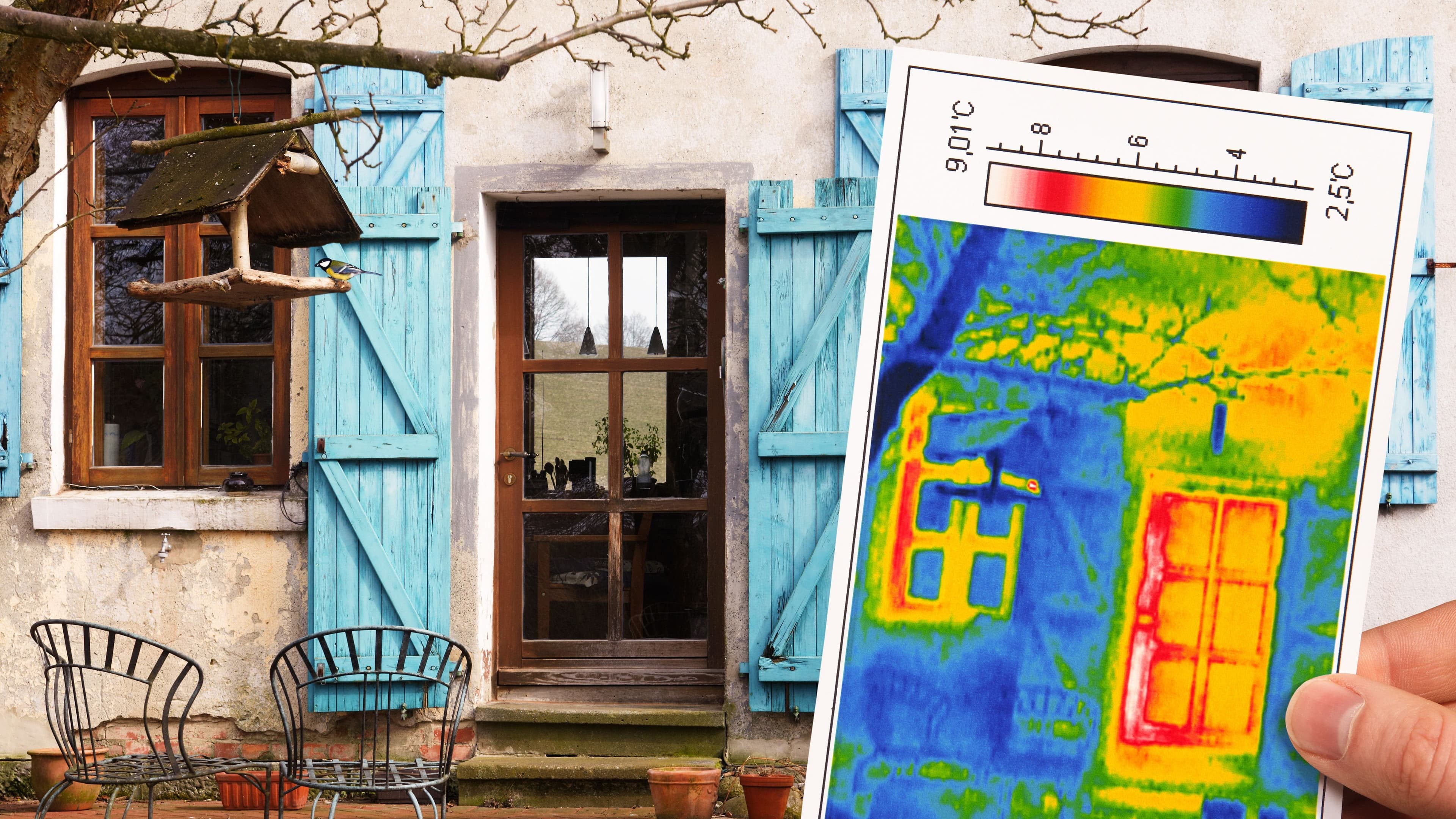 Eine Hand hält einen Ausschnitt einer Thermografie in den Vordergrund. Im Hintergrund befindet sich ein Haus mit einer Tür.